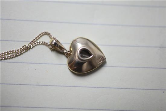 An 18ct gold and diamond encrusted heart shaped pendant with central pear shaped diamond, pendant 14mm.